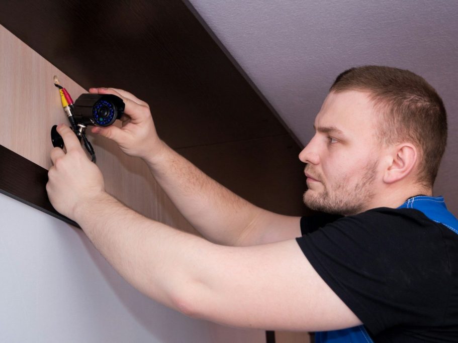 Smart Home Installation & Wartung deutschlandweit-Formavis Ein Handwerker installiert eine Wandhalterung mit Werkzeug in der Hand.